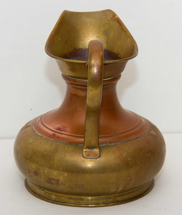 Large brass jug with wide copper band brass spout and handle display