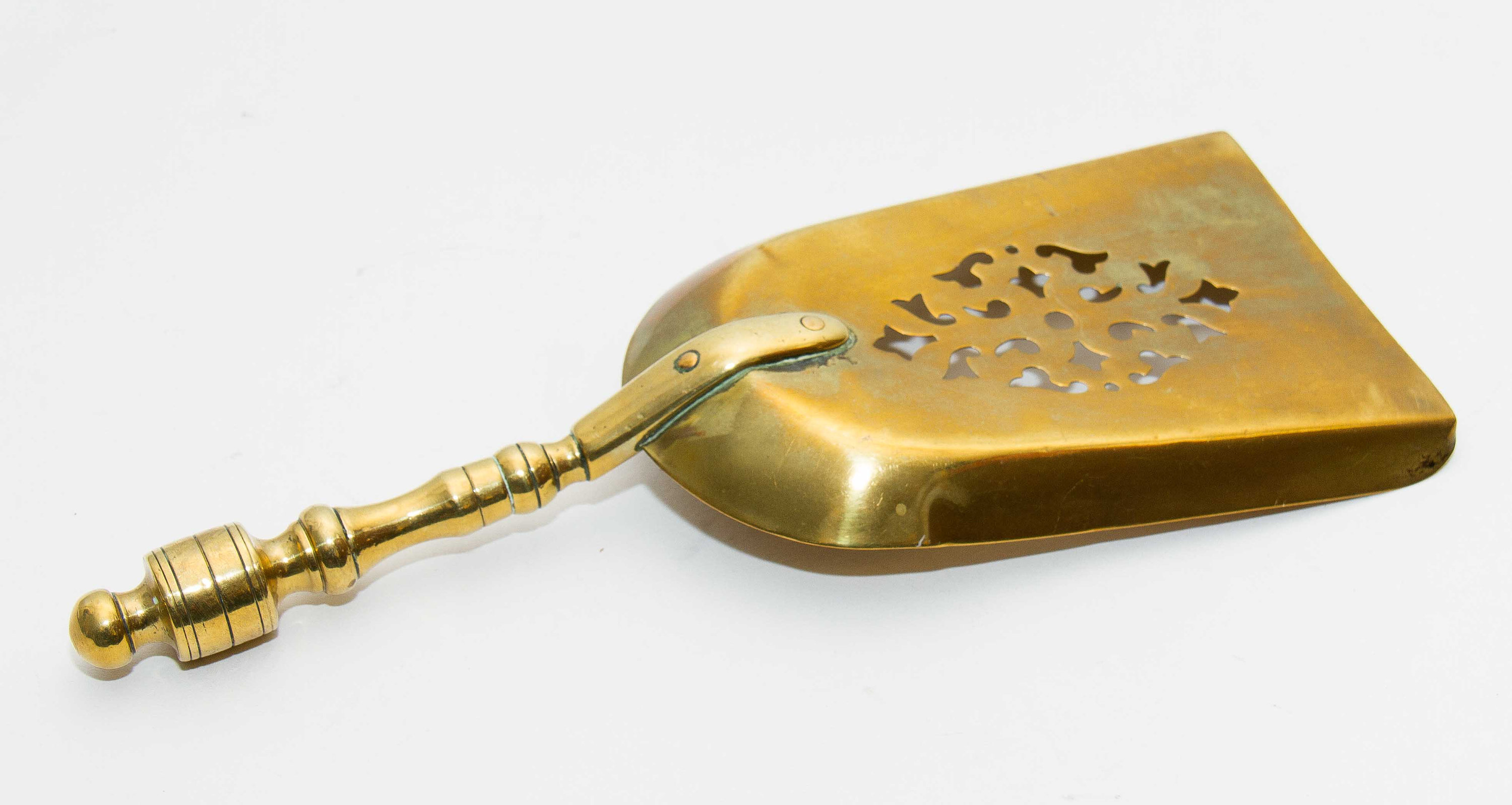 Brass decorative shovel cut out pattern fireside coal shovel fireplace accessory. Display prop bar cafe pub restaurant