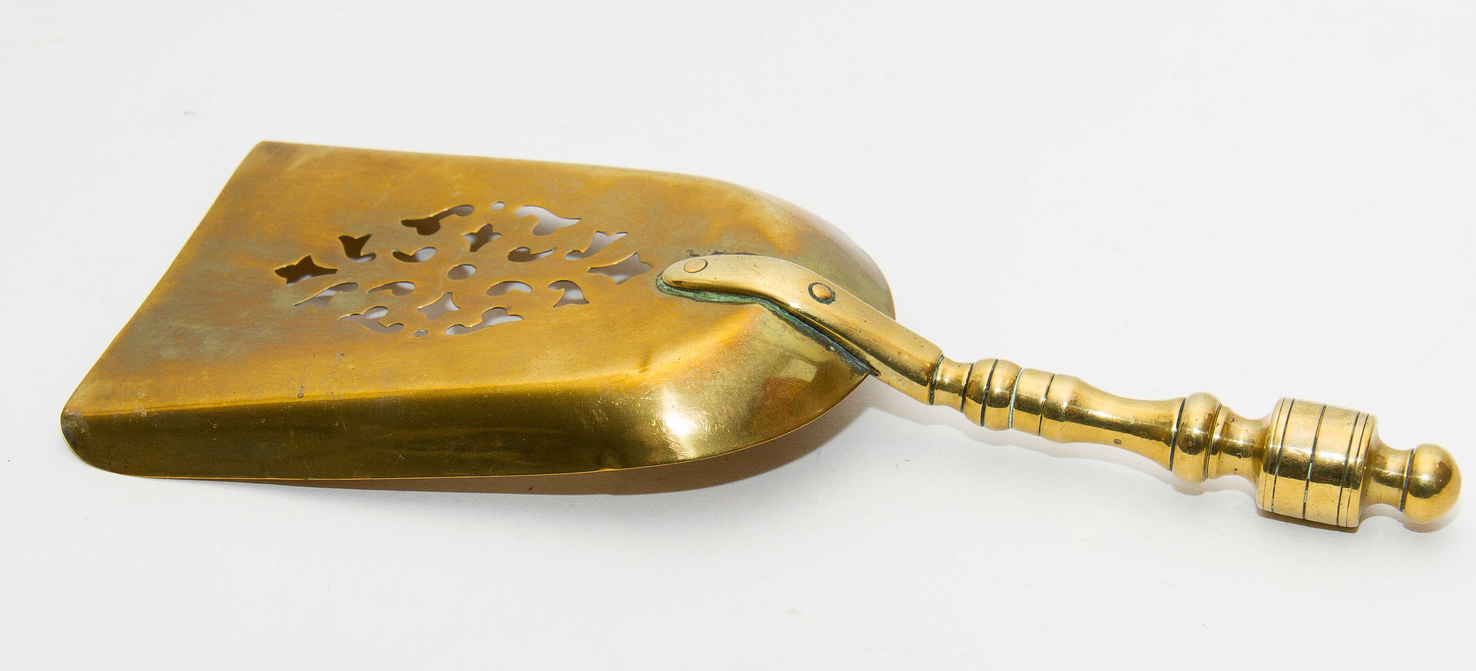 Brass decorative shovel cut out pattern fireside coal shovel fireplace accessory. Display prop bar cafe pub restaurant