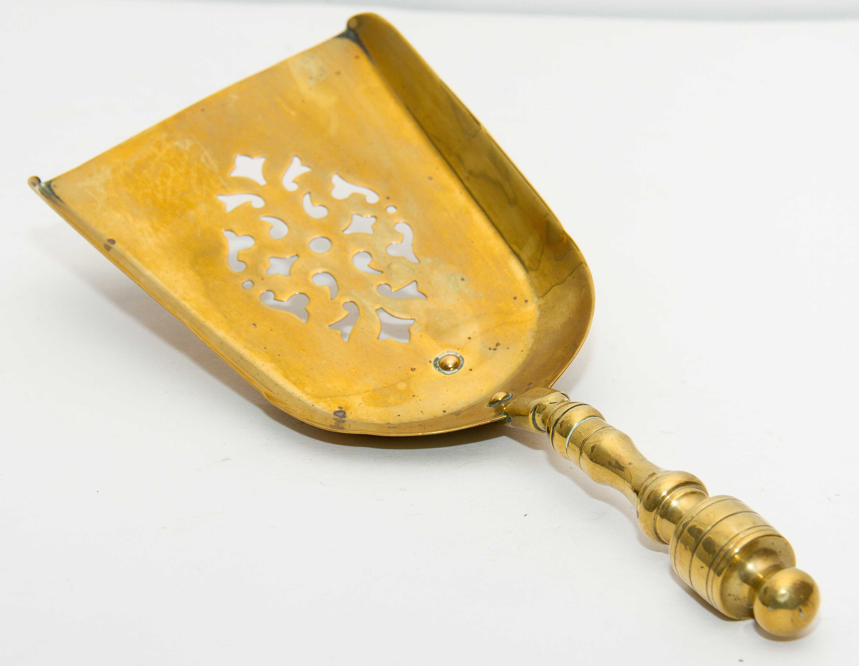 Brass decorative shovel cut out pattern fireside coal shovel fireplace accessory. Display prop bar cafe pub restaurant