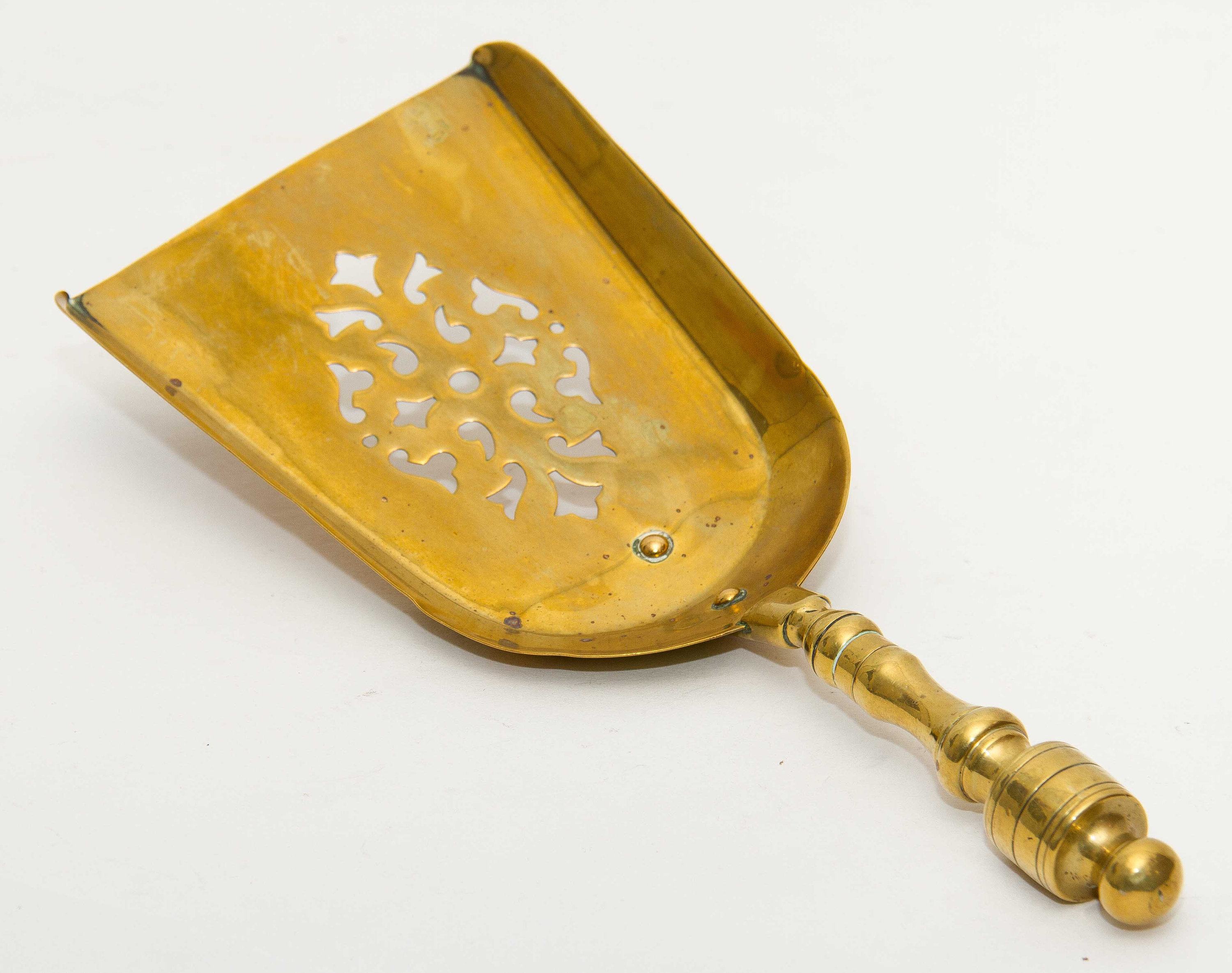 Brass decorative shovel cut out pattern fireside coal shovel fireplace accessory. Display prop bar cafe pub restaurant