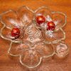 A large vintage glass dish in the shape of a leaf, separated into 4 sections.