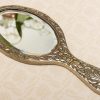 A quality vintage silver plated ornate hand vanity mirror. The mirror is a good weight and has a bevel edge mirror.